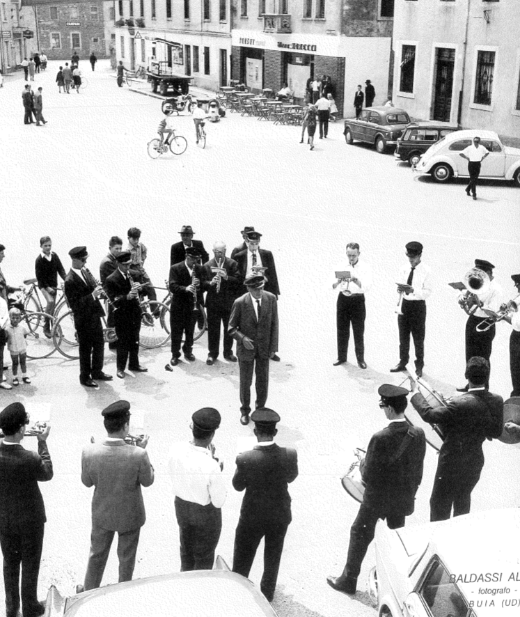 1964 piazza Madonna. I bandisti fanno circolo attorno al loro maestro Vriz. (Arch. Ass.ne Filarmonica)